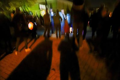 People walking in illuminated city at night