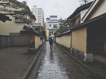 Rear view of people walking on road in city