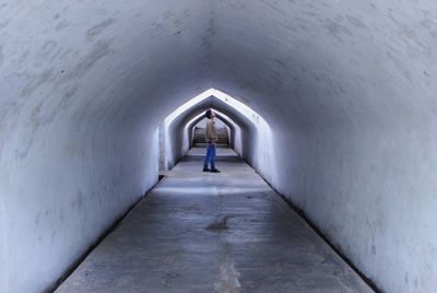 Side view of young man standing in tunnel