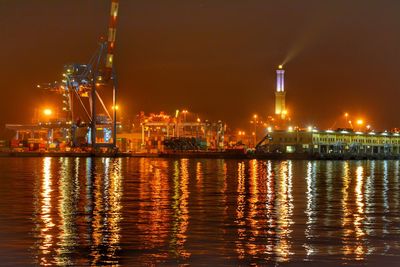 Illuminated harbor against sky at night