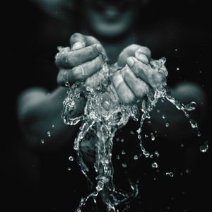 Midsection of man splashing water