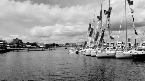 Sailboats moored in harbor