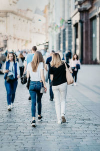 Rear view of women walking on footpath