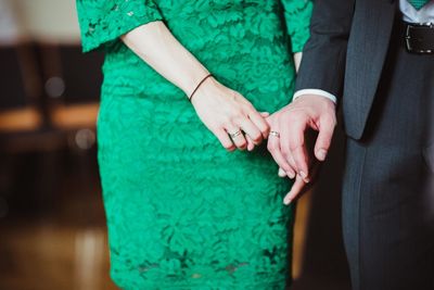 Midsection of bride and groom holding hands