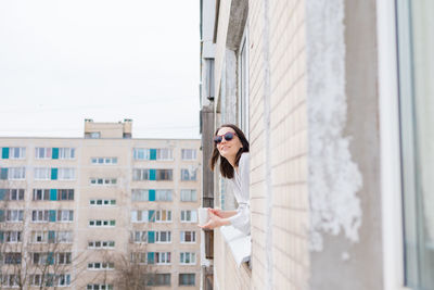 Low angle view of woman standing against building