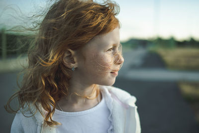 Thoughtful cute redhead girl with freckles, portrait