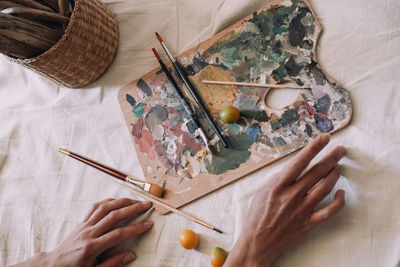 Palette with paints on a white sheet. brushes and paints