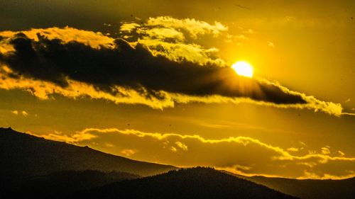 Scenic view of silhouette mountains against sky during sunset