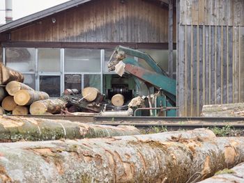 Stack of logs against building