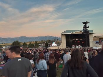 Rear view of people at town square against sky during sunset