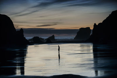 Mid distance view of silhouette person standing at bandon beach person