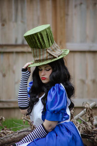 Portrait of young woman wearing hat standing outdoors