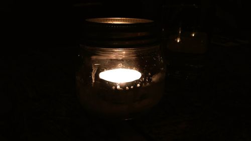 Close-up of lit candle in dark room