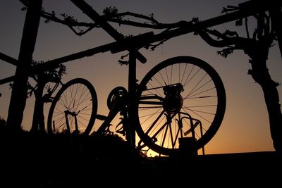 Silhouette of bicycle against sky during sunset