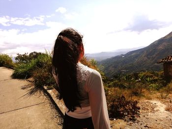 Rear view of girl standing against mountain