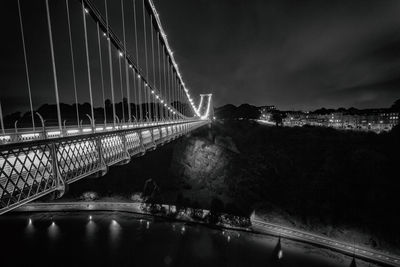 Illuminated suspension bridge in city at night