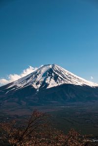 Scenic view of snowcapped mountains against clear blue sky