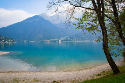 Scenic view of lake by mountains against sky