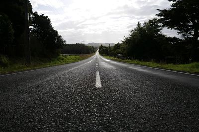 Road amidst trees against sky
