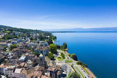 High angle view of townscape by sea against sky