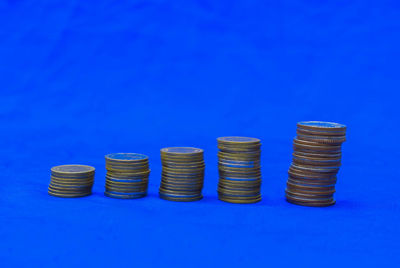 Close-up of coins arranged on blue background