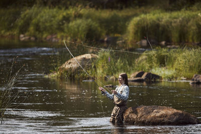 Woman fishing in lake