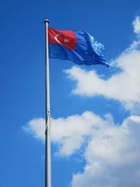 Low angle view of flag against blue sky