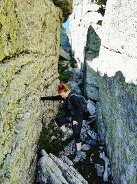 Woman hikes in rocky terrain.