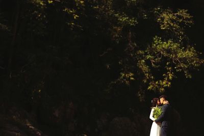 Rear view of woman standing in forest