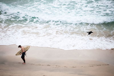 Full length of shirtless man standing on beach