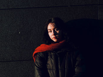 Young woman standing against wall