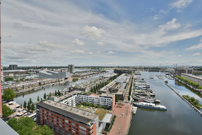 High angle view of buildings by river against sky