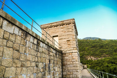 Low angle view of dam against blue sky