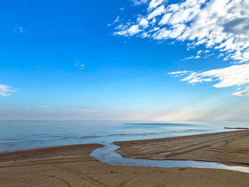 Scenic view of beach against blue sky