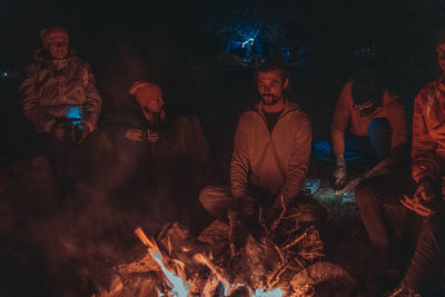 Group of people against fire at night