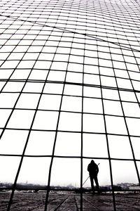 Silhouette man standing by sea against sky