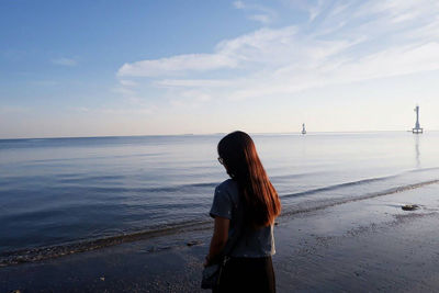 Rear view of woman standing on beach