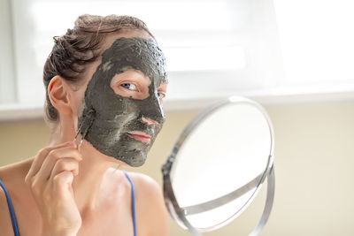 Portrait of woman applying face mask