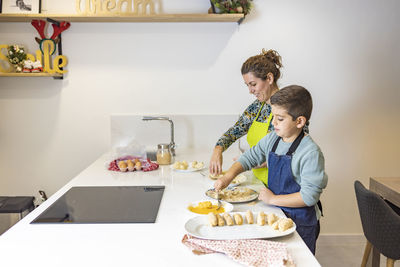 Mother and son making croquettes in the kitchen