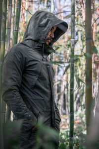 Moroccan man wearing a green winter jacket standing in the middle of a bamboo forest in morocco