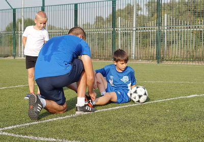 Boys playing soccer on field