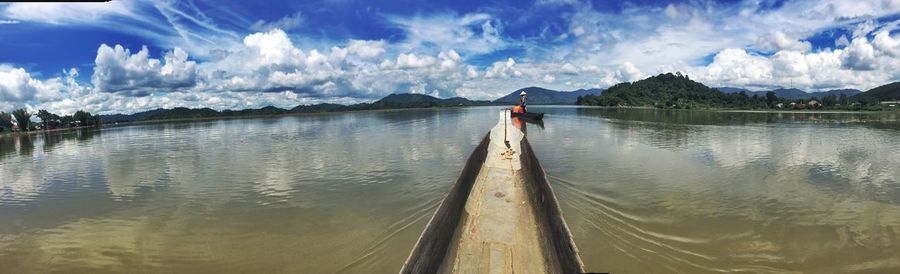 Rear view of man on water against sky