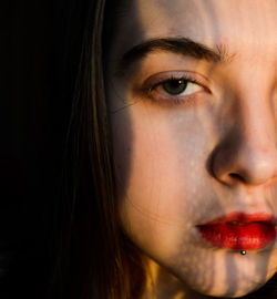 Close-up portrait of young woman with red lipstick