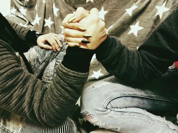 Midsection of people arm wrestling at home