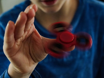 Midsection of man spinning fidget spinner