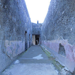 Corridor amidst buildings against sky