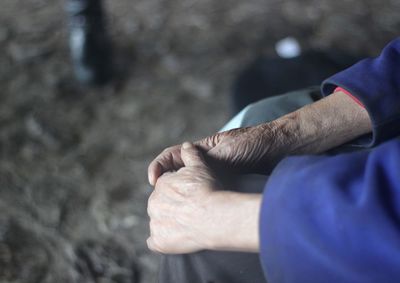 Midsection of person sitting outdoors