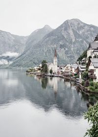 Scenic view of lake by buildings against sky