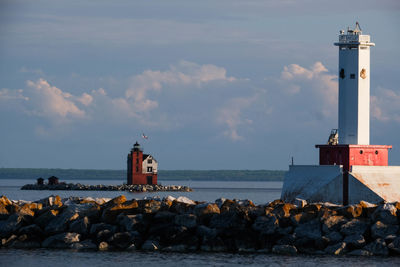 Lighthouse by sea against sky