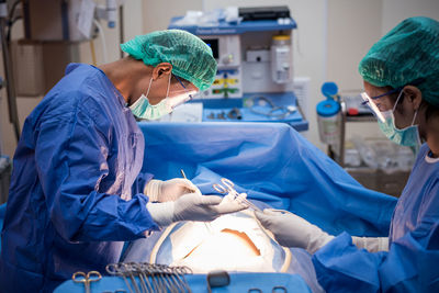 Surgeons operating patient in hospital